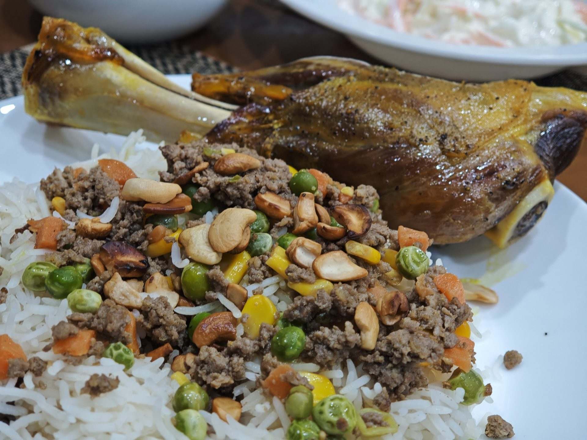 Close-up of a Palestinian ozi lamb shank over rice with minced meat and nuts